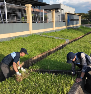 Membersihkan drainase luar perusahaan